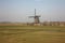 Lonely windmill in the provincial, clean and green countryside of Holland. sky with a bit of mist and pristine green meadows