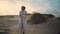 Lonely woman admiring beach dunes. Black hair model get cold resting seaside