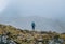 Lonely woman with backpack and trekking poles going by mountain route during Makalu Barun National Park near Tuli Kharka