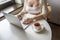 Lonely woman freelancer enjoying having breakfast with cup of coffee working on laptop sitting near window in cafe at morning.