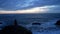 lonely woman in jacket sitting at the wavy sea with dramatic sky, loneliness