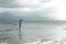 Lonely woman looks at infinity and uncontaminated nature on a stormy day