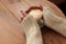 Lonely woman with nice manicure in warm wood sweater drinking coffee in the morning, top view of female hands holding cup of hot