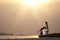 Lonely woman sitting on lake coast