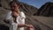 Lonely woman is sitting on stone in desert, romantic female portrait