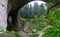 Lonely woman standing on wonderful bridge in Bulgaria. Famous and mysterious open wide cave. Magnificent rock formation and girl