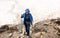 A lonely woman in tourist outfit hikking on a glacier in the mountains