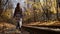 lonely woman is walking alone over old tram rails in sunset in autumn