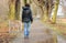 Lonely woman walking in park on cold rainy day