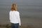 Lonely woman in white casual outfit with Blond hair sitting