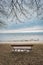 Lonely wooden bench on the autumn sea with cloudy sky