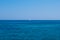 Lonely yacht in an open sea under solid blue sky