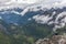 A lonely young girl sits on the edge of a mountain. View to Geiranger fjord and eagle road in cloudy weather from Dalsnibba