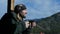 Lonesome bearded man standing on observation deck looking on a mountain and drinking coffee or tea from big cup. slow