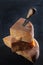 Long-aged cheese chunks. Hard cheese with a knife on a dark background. Top view. Firm texture of cheese