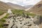 A long ancient wall of Tibetan Buddhist mani stones on a trekking trail to a village in the Zanskar