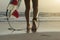 Long angle of surfer walking along beach with ankle leash and board fins