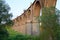 long arched railway bridge over a green ravine on a summer evening