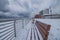 Long Beach New York - December 30, 2017 : Snow covered benches on the boardwalk under dramatic dark storm clouds