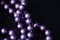 Long beaded necklace purple color on a dark background