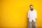 Long bearded hipster on yellow wall