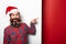 Long bearded man in santa claus hat pointing away