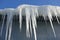 Long, big and dangerous icicles on a brick house roof