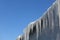 Long, big and dangerous icicles on a brick house roof