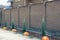 Long brown brick fence in the street with small coniferous ornamental trees