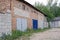 Long brown wall of an old garage with a row of iron gates