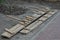 Long brown wooden formwork boards lie on gray ground