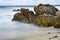 Long camera exposure of ocean waves against rocky coast