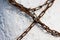 A long chain made of metal is covered with a little rust wrapped around the concrete wall and prohibits any movement.