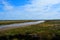 Long coastal stream / river and blue sky, Blakeney Point, Norfolk, United Kingdom