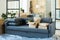 Long comfortable soft blue couch with two cushions and several boxes