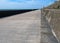 Long concrete pedestrian walkway along the seawall in blackpool lancashire with summer sunshine and sea