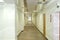 A long corridor with doors to offices. Marble floors, mirrored ceiling