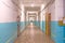 A long corridor with doors to offices. Marble floors. Old industrial building.