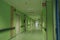 The long corridor of the hospital with doors, and rooms with medical equipment and hospital furniture.