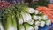 Long counter with various fresh vegetables for salad, wholesale market trade