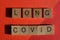 Long Covid, words in 3d wooden alphabet letters isolated on red