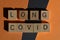 Long Covid, words in wooden alphabet letters isolated on orange and black background