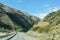 Long curve concrete road along mountain range in New Zealand