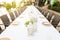Long dining table at wedding. Tableware decorations with white tablecloths at outdoor wedding