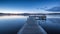 a long dock sitting on top of a lake under a blue sky