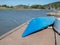 Long dormant kayaks sitting on a dock overlooking a river in a sunny neighborhood