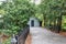 Long driveway with blue outdoor shed wood building for storage and a fence