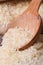 Long dry rice macro spill out of a wooden spoon