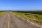 Long empty country road in rural Texas along a cornfield; Concept for travel in Texas