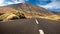 Long empty highway road in the desert going to mountains. Road to volcano Teide, Tenerife, Spain